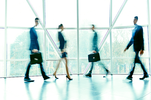 Busy managers moving inside office building