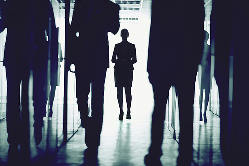 Outlines of business people walking down office center