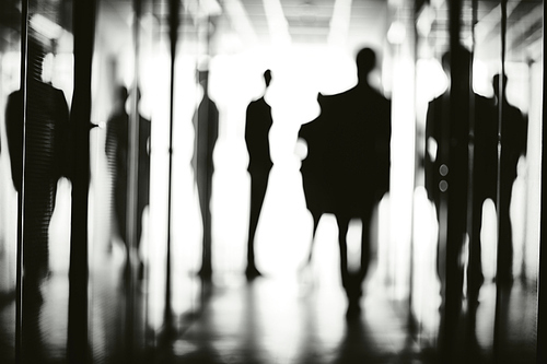 Silhouettes of several office workers in corridor of business center