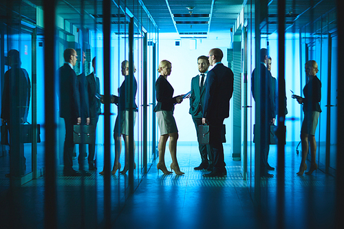 Group of colleagues consulting in corridor of business center