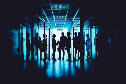 Group of co-workers interacting at meeting in corridor of business center