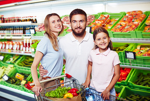 Portrait of happy family shopping for groceries in supermarket