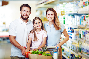 Cheerful family with shopping cart buying products