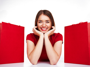 Smiling girl  between two red paperbags