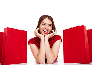 Modern shopper lying between red paperbags