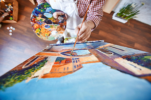 Male artist painting street of Venice on canvas