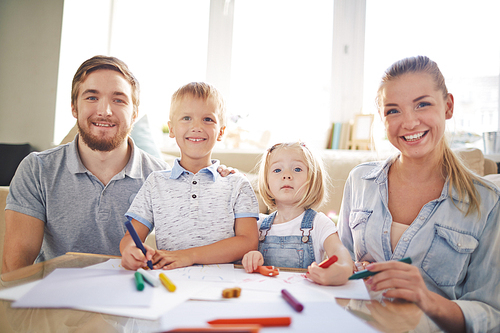 Cute children and their parents drawing at leisure