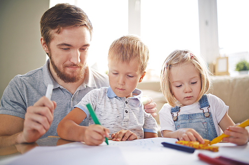 Cute siblings drawing with father
