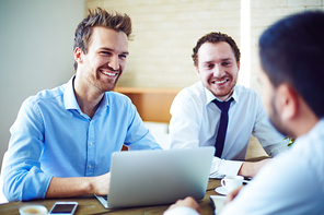 Cheerful businessmen listening to candidate for vacancy