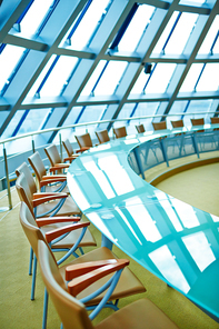 Empty conference hall for meetings and trainings with large round table and chairs around it