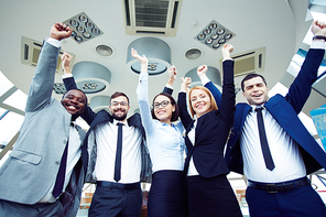 Successful business team standing with raised arms