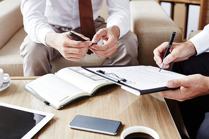 Businessman pointing at contract while showing his partner where to sign it