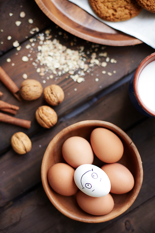 Several eggs in bowl with walnuts, milk and cinnamon near by