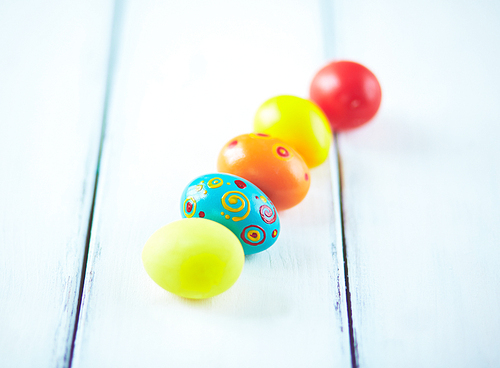 Row of painted eggs on wooden table