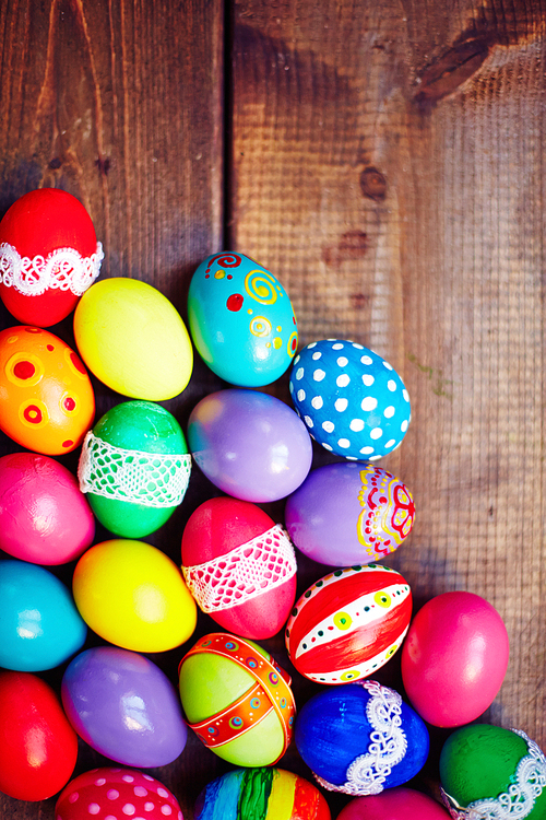 Easter eggs of different colors on wooden background