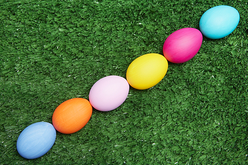 Line of painted eggs on green grass