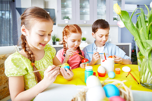 Children painting eggs with gouache