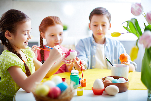 Children painting eggs at school