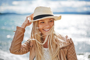 Blond girl in hat spending leisure by the seaside