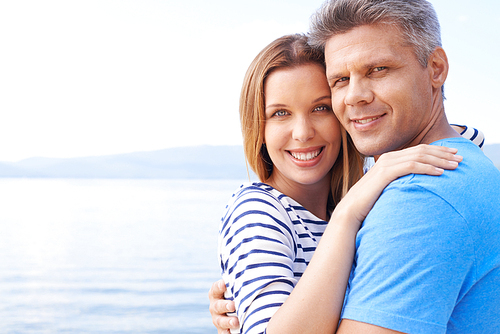 Affectionate man and woman enjoying summer vacation by sea