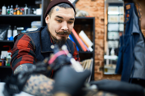Young man visiting tattooer for making tattoo