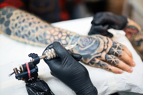 Creative tattooist holding machine for drawing tattoo