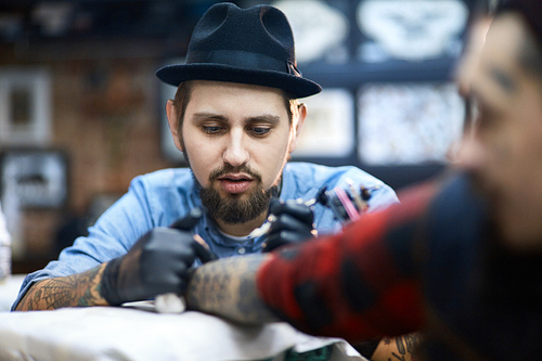 Concentrated master of tattooing during work