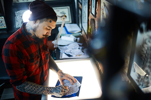 Creative young man making sketch of ornament