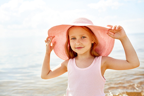 Little beauty in hat enjoying summer vacation at resort