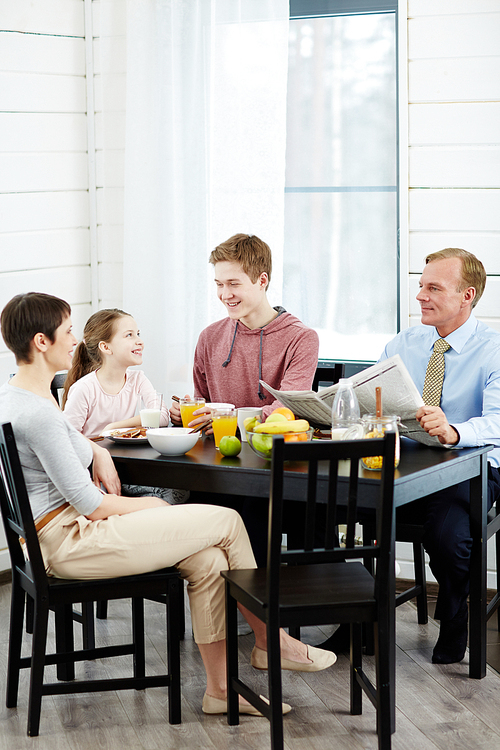 Family talking by kitchen table after meals
