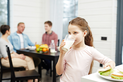 Healthy girl drinking milk from glass in the kitchen