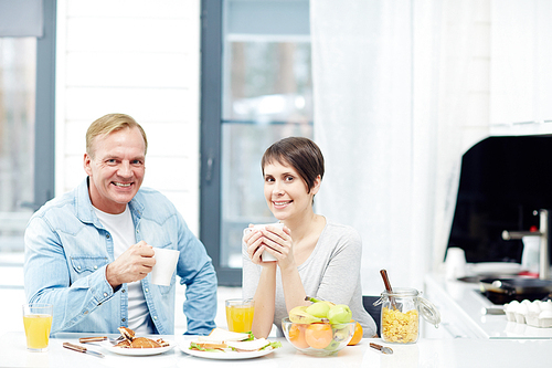 Healthy young couple eating breakfast at home