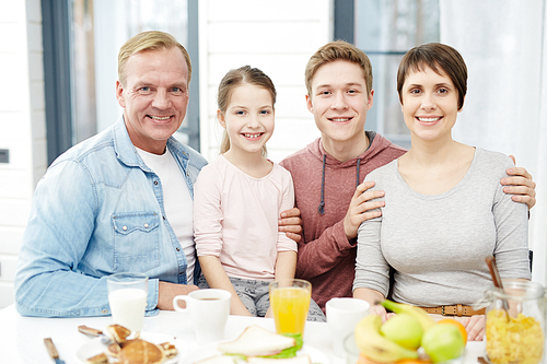 Affectionate family sitting by kitchen table