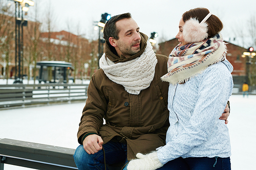 Man and woman in winterwear talking outdoors