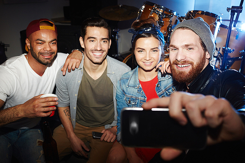 Young men and woman making selfie while enjoying party
