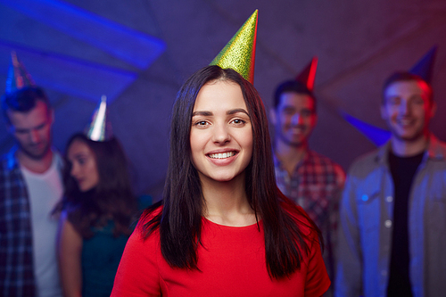 Adolescent female in birthday-cap  on background of her friends