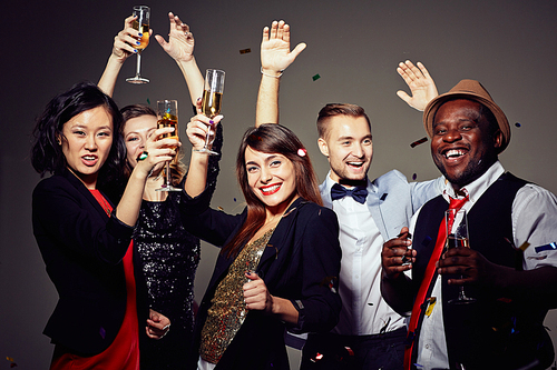 Three attractive young women and two handsome men gathered together in trendy night club and celebrating New Years Eve, group portrait