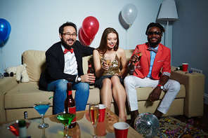 Two bearded men with beer bottle and champagne flute  while their pretty female friend sitting between them