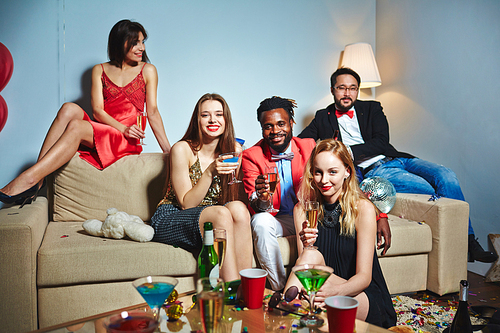 Posh young people toasting with champagne at home party