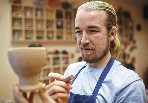 Creative man holding self-made clay jug