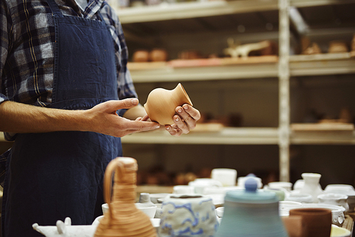 Pottery craftsman holding small ceramic jug