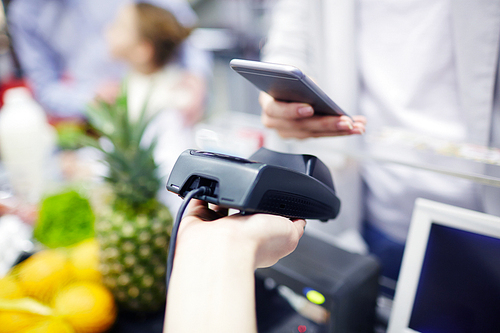 Buyer paying by nfc system for food products in supermarket