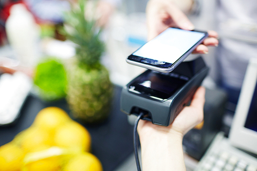 Customer using modern media technologies to make payment in supermarket