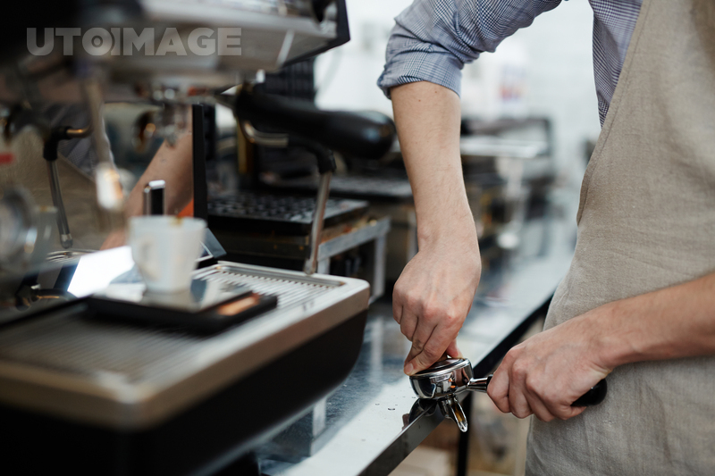 유토이미지 | Modern barista grinding coffee beans