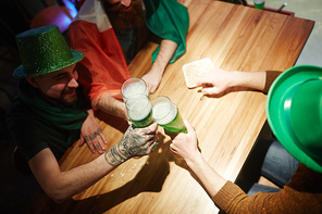 Group of irish men with beer sitting by table in pub