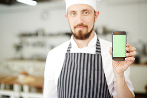 Kitchen staff showing special offer in smartphone