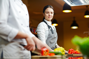 Young staff of restaurant cooking vegetables