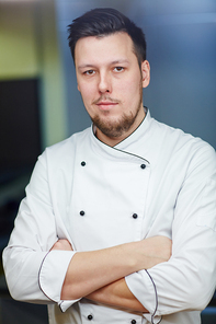 Young chef in uniform crossing his arms on chest