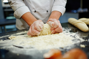 Professional baker kneading dough for bread or pastry