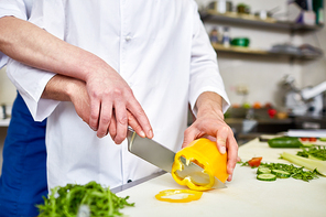 Trainee and chef slicing ingredients for salad